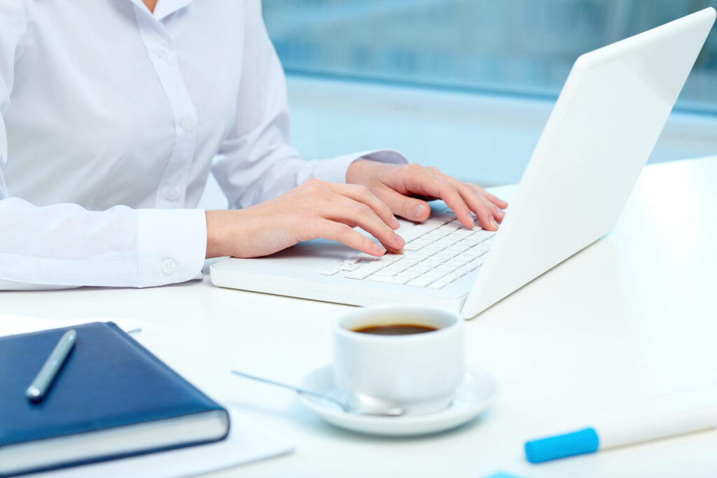 Close-up of female hands typing on laptop