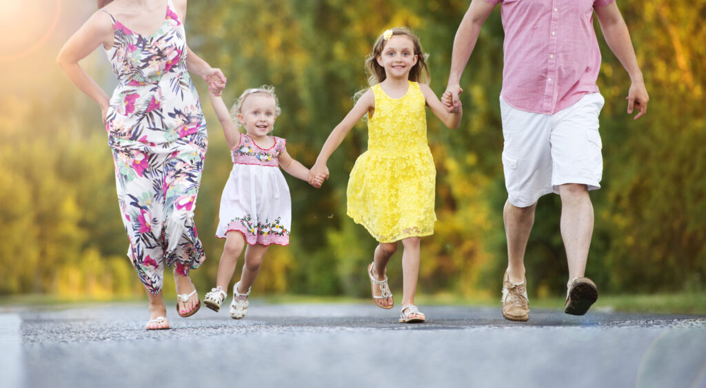 Happy family having fun during the walk on the road