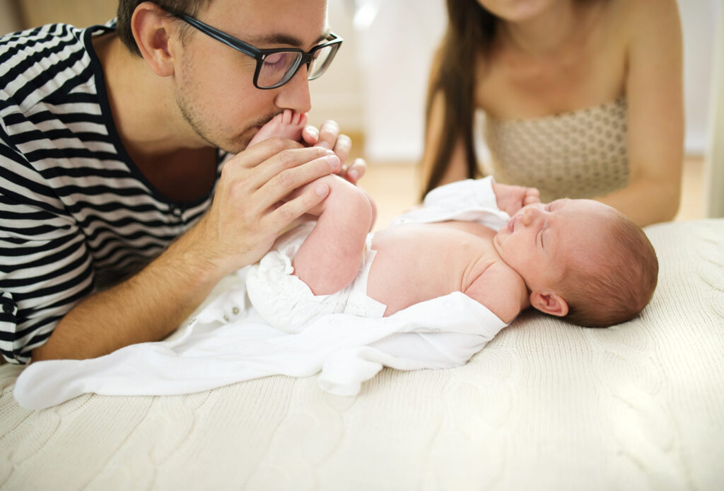 Happy young parents with their newborn baby girl at home
